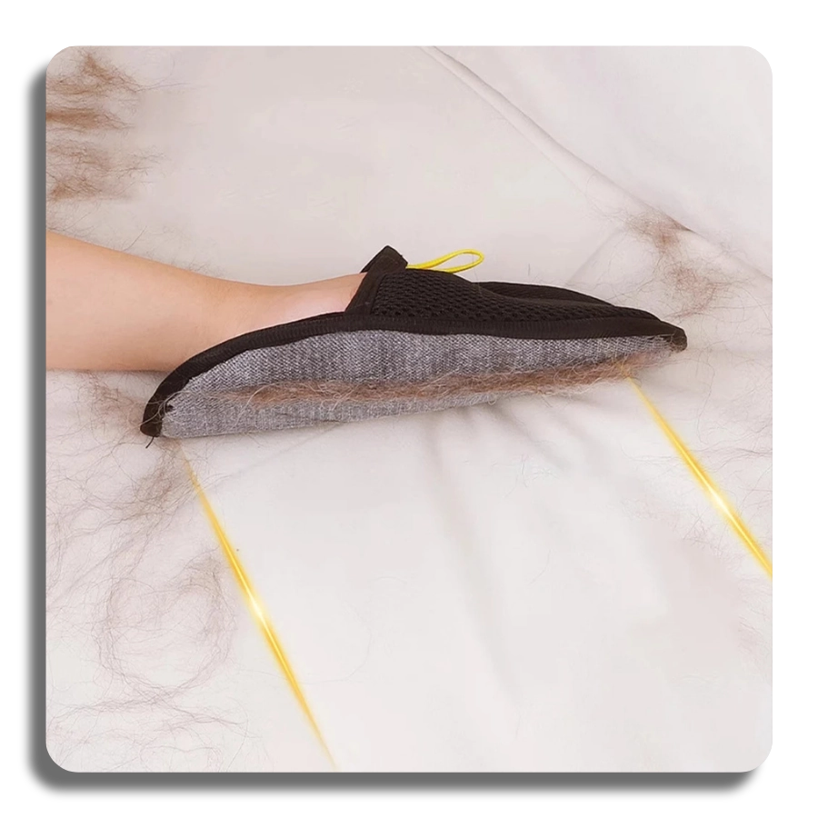 Grooming mitt being used on a white bed sheet to remove loose pet fur, showcasing its efficiency on different fabric surfaces.