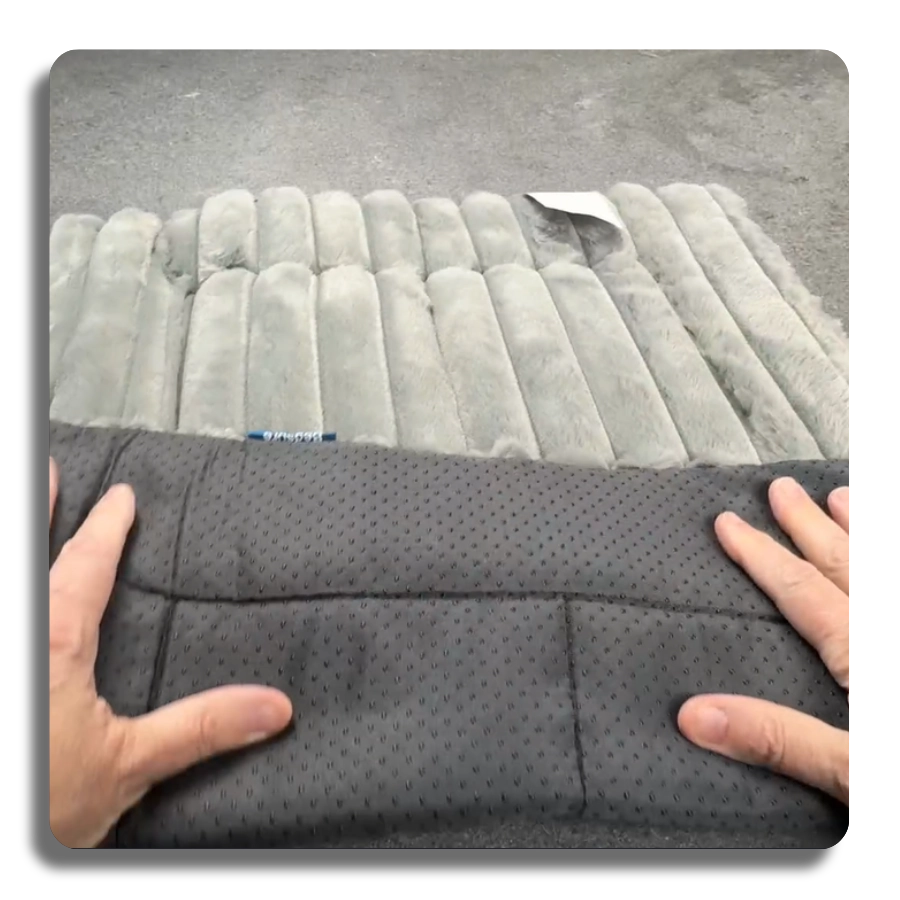 Close-up of the non-slip rubberized bottom and plush grey corduroy top of the self-warming pet mat, demonstrating safety and durability.